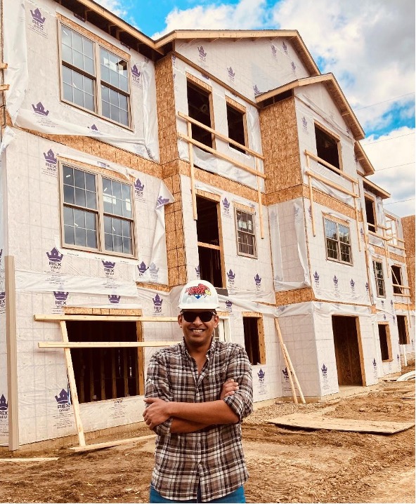 A picture of Saurabh standing in front of a construction site. 